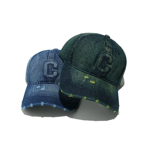 Close-up of vintage distressed denim baseball caps with embroidered C letter and frayed edges