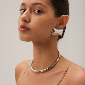 Polished silver rectangular drop earrings and minimalist collar necklace set on a model