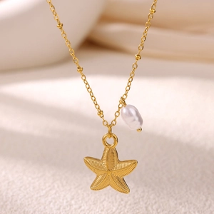 Close-up of golden starfish charm and freshwater pearl pendant on a beach style necklace