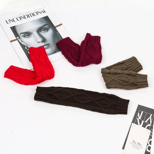 Close-up of knit arm warmers in four colors with classic cable stitch patterns