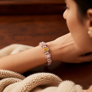 Detail of rose gold bracelet featuring pink and yellow rectangular zircons on wrist