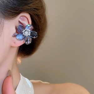 Close-up of elegant blue crystal flower ear cuff with white zircon details on model