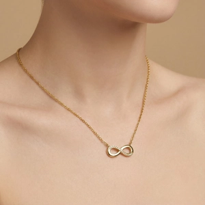 Detailed view of an 18k gold plated infinity symbol pendant necklace with sparkling zircons