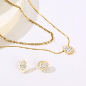 Dettaglio del set collana doppia catena dorata e pendenti a goccia in zirconi cubici