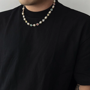 Collier hip-hop homme en perles avec pendentifs soleil colorés sur un t-shirt noir