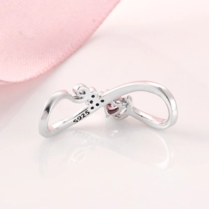Macro shot of S925 sterling silver infinity ring detail with heart-shaped pink zircon stone