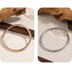 Detail of 4mm solid smooth bangles in rose gold and silver finishes on natural background