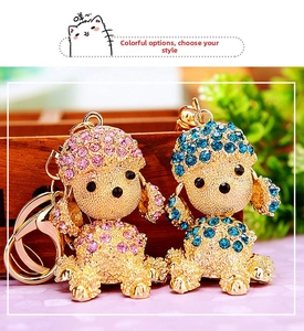 Detail view of pink and blue rhinestone-encrusted poodle keychains with gold lobster clasps