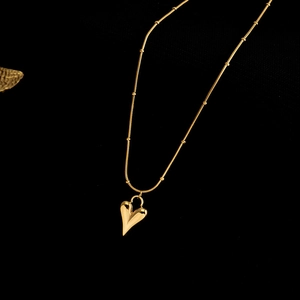 Elegant gold heart pendant necklace with beaded chain on premium black background