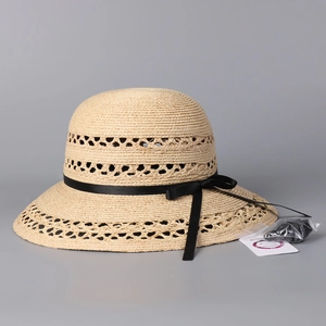 Detail of raffia straw hat with hollow weave pattern and UPF 50+ sun protection tag