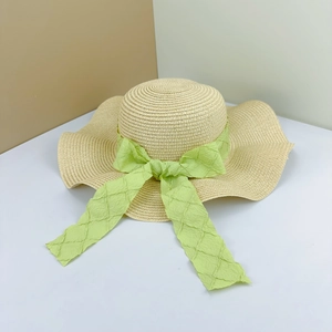 Summer wide brim straw hat in natural color with a light green textured bow ribbon