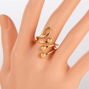 Spiral gold ring with frosted beads and a single rhinestone shown on a model hand