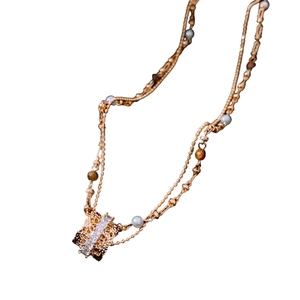 Double-layered rose gold necklace featuring tiger eye, pearls, and zircon pendant