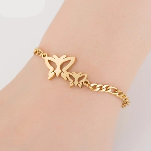 Detailed view of a gold titanium bracelet featuring double hollow butterfly charms on a wrist