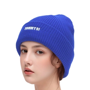 Gros plan sur un bonnet en maille côtelée bleu roi avec broderie blanche Tommy Ri