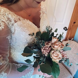 Detail of white bridal gown featuring delicate lace appliques and a deep V-neckline