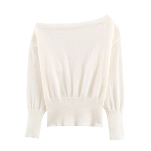 Close-up of white off-shoulder knit sweater showing ribbed cuffs and fine texture