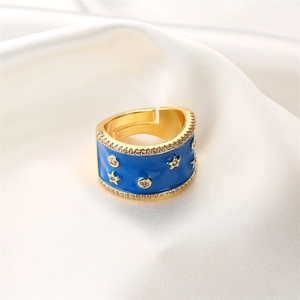 Dettaglio macro dell'anello a stella dorato con smalto blu e pietre di zircone lucido