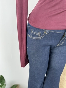 Detailed close-up of dark blue denim jeans paired with a burgundy slim-fit knit sweater
