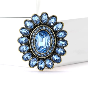 Anello girasole vintage dorato con cristalli blu su uno sfondo bianco pulito