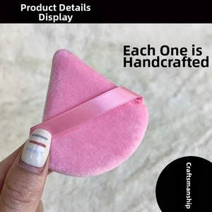 Macro detail of a pink triangular makeup puff showing soft flocking and ribbon handle