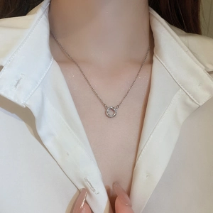 Close-up of minimalist silver stainless steel circle necklace with pavé zircon details