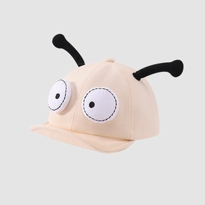 Detail of beige baby sun hat featuring funny cartoon big eyes and soft black tentacles