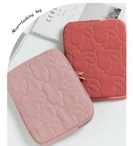 Detail view of quilted tablet sleeve with cute rabbit pattern on minimalist white background