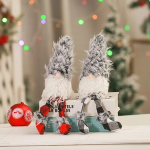 Detail of plush Christmas gnome with long legs on books with festive bokeh background