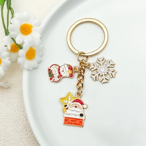 Festive gold enamel keychain with snowman, snowflake and Santa Claus charms for bags