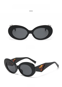 Detail of oval cat-eye sunglasses featuring black frames and tortoise shell temple accents