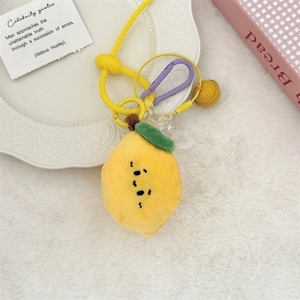 Détail du charm citron en peluche jaune avec mousqueton violet, clochette et perles