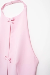Nahaufnahme eines rosa Neckholder-Tops mit Schleifendetails und feiner Webstruktur