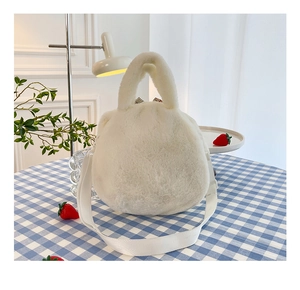 Rear view of white plush crossbody bag on a checkered table with strawberries
