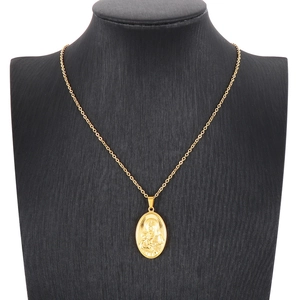 Golden stainless steel oval Virgin Mary pendant necklace displayed on a black bust mannequin