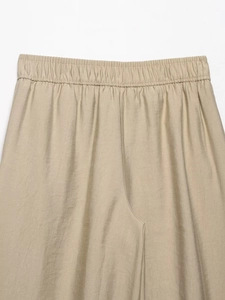 Detailed view of elastic waistband and woven fabric texture on khaki wide-leg trousers
