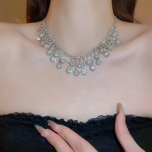 Close-up of sparkling silver rhinestone tassel necklace worn by a model on neck