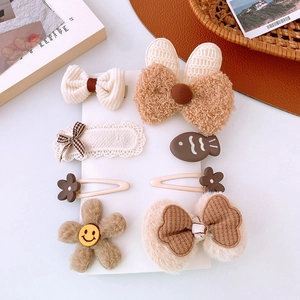Dettaglio di fiocchi in peluche e fermagli per capelli a coniglio su carta display