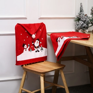 Detail of red Christmas chair covers featuring festive snowman and tree patterns