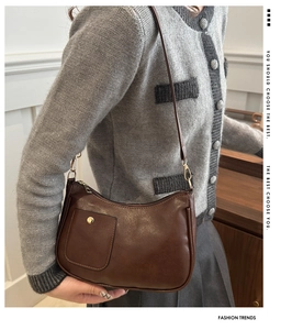 Detail view of a vintage dark brown PU leather crescent shoulder bag with small front pocket