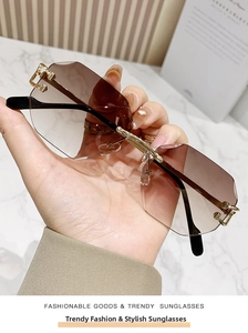 Detail of rimless polygon sunglasses with brown gradient lenses and gold metal temples
