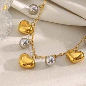 Collier plaqué or 18K avec breloques cœur creux et perles argentées sur une chaîne métal