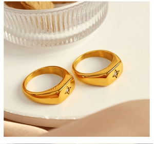 Detail view of 18k gold plated stainless steel star zircon rings on a marble tray