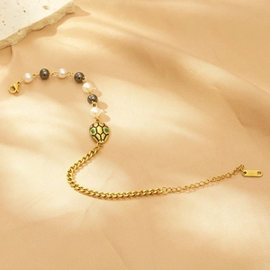 Detail of golden snake head pendant bracelet with pearls and K18 hallmark on silk background