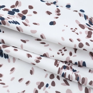 Close-up of white textile fabric with brown and navy blue abstract printed patterns