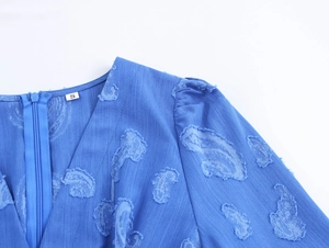 Détail du col en V avec fermeture éclair et étiquette de taille S sur la robe bleue