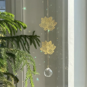 Detail of crystal lotus suncatcher showing golden metal leaves and a faceted prism ball