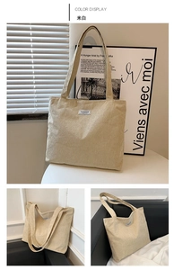 Detail view of large corduroy tote bag in creamy white with fashion textile label