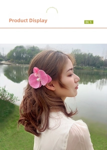 Detail view of pink orchid hair clip with white pearl center worn on a model outdoors