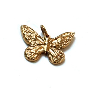 Detailed view of a golden butterfly pendant with intricate textured wings for jewelry DIY